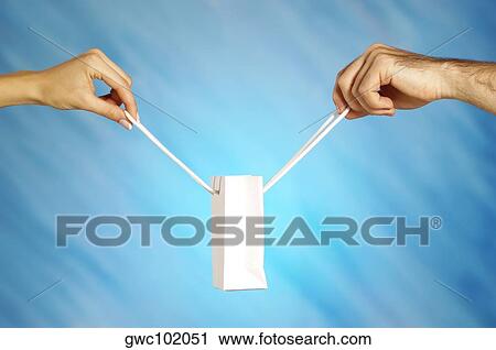 Close-up of a man and a woman's hands holding a shopping bag View Large Photo Image Stock Image - Close-up of a man and a woman's hands holding a shopping bag. Fotosearch