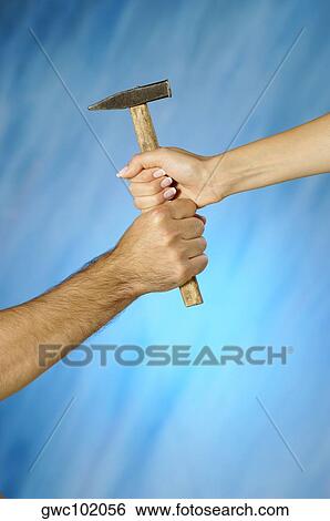 Close-up of a man and a woman's hands holding a hammer View Large Photo Image Stock Photograph - Close-up of a man and a woman's hands holding a hammer. Fotosearch