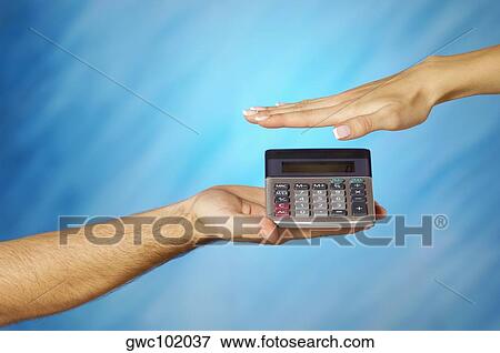 Close-up of a man holding a calculator with a woman's hand above it View Large Photo Image Stock Photo - Close-up of a man holding a calculator with a woman's hand above it. Fotosearch