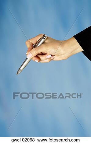Close-up of a woman's hand holding a pen View Large Photo Image Stock Photo - Close-up of a woman's hand holding a pen. Fotosearch