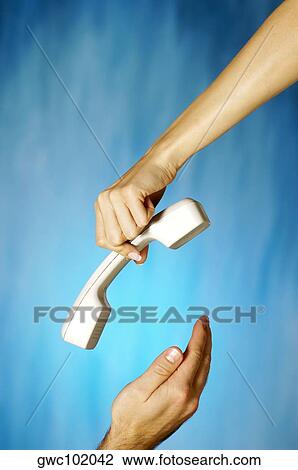 Close-up of a woman's hand holding a telephone receiver above a man's hand View Large Photo Image Stock Image - Close-up of a woman's hand holding a telephone receiver above a man's hand. Fotosearch