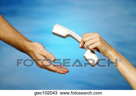 Close-up of a woman's hand holding a telephone receiver above a man's hand View Large Photo Image Stock Image - Close-up of a woman's hand holding a telephone receiver above a man's hand. Fotosearch