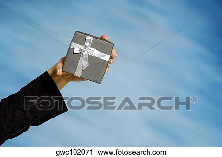 Close-up of a woman's hand holding a gift View Large Photo Image Stock Image - Close-up of a woman's hand holding a gift. Fotosearch