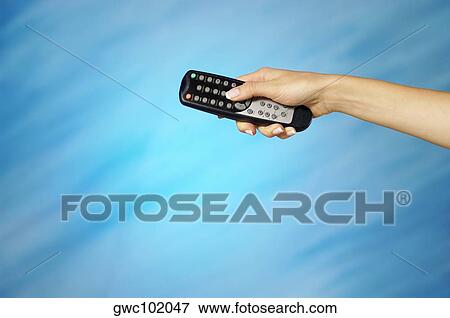 Close-up of a woman's hand holding a remote control View Large Photo Image Stock Photo - Close-up of a woman's hand holding a remote control. Fotosearch