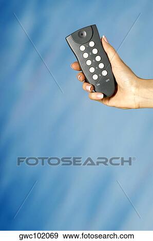 Close-up of a woman's hand holding a remote control View Large Photo Image Stock Photo - Close-up of a woman's hand holding a remote control. Fotosearch