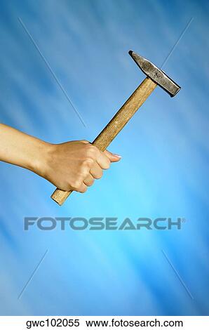Stock Photography - Close-up of a woman's hand holding a hammer. Fotosearch