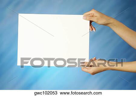 Stock Image - Close-up of a woman's hands holding a placard. Fotosearch