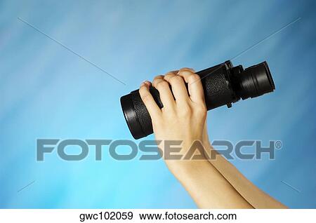 Woman's hands holding a pair of binoculars View Large Photo Image Stock Photo - Woman's hands holding a pair of binoculars. Fotosearch