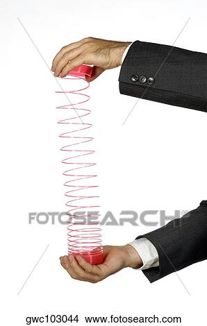 Close-up of a businessman holding a coiled spring View Large Photo Image Picture - Close-up of a businessman holding a coiled spring. Fotosearch