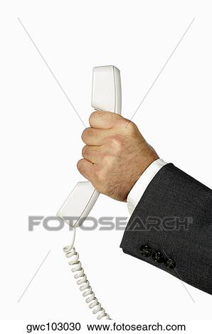 Stock Image - Close-up of a businessman holding a telephone receiver. Fotosearch