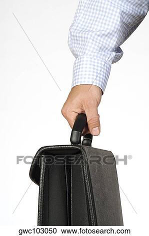 Stock Image - Close-up of a businessman holding a briefcase. Fotosearch
