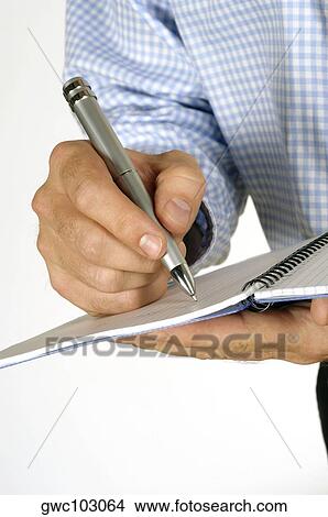 Picture - Close-up of a businessman writing in a notebook. Fotosearch
