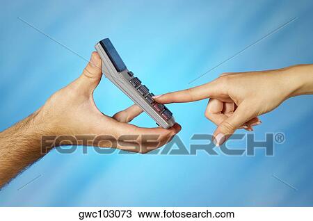 Stock Image - Close-up of a man holding a calculator with a woman's finger pressing a button. Fotosearch
