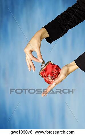 Close-up of a woman's hand inserting a coin into a change purse View Large Photo Image Stock Photograph - Close-up of a woman's hand inserting a coin into a change purse. Fotosearch