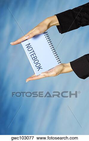 Close-up of a woman's hands holding a spiral notebook View Large Photo Image Stock Photo - Close-up of a woman's hands holding a spiral notebook. Fotosearch