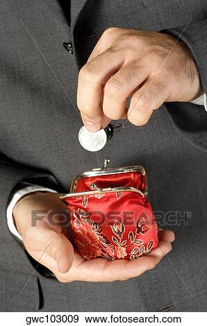 Stock Photo - Mid section view of a businessman putting money into a change purse. Fotosearch