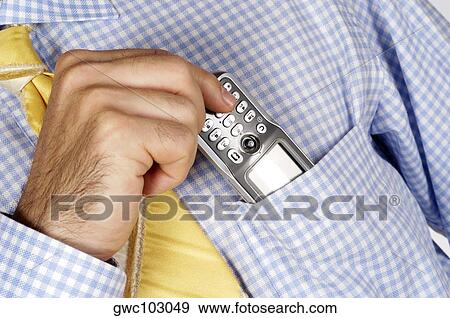 Stock Photo - Mid section view of a businessman putting a mobile phone into his shirt pocket. Fotosearch