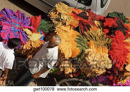 High angle view of a senior man and a mid adult man standing near a cart loaded with clothes View Large Photo Image Stock Photo - High angle view of a senior man and a mid adult man standing near a cart loaded with clothes. Fotosearch