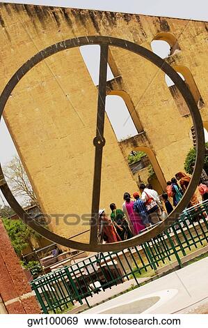Stock Photo - Rear view of tourists looking at a monument, Jantar Mantar, Jaipur, Rajasthan, India. Fotosearch
