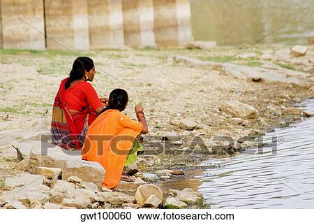 Two women sitting on the banks of a river, Gadi Sagar, Jaisalmer, Rajasthan, India View Large Photo Image Stock Image - Two women sitting on the banks of a river, Gadi Sagar, Jaisalmer, Rajasthan, India. Fotosearch