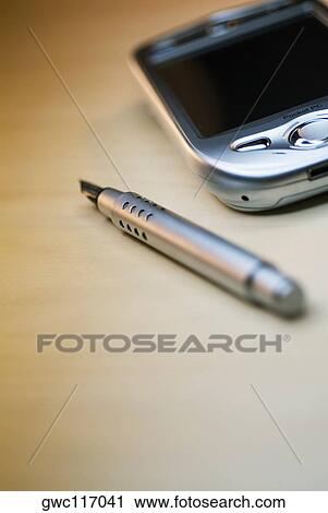 Stock Image - Close-up of a fountain pen with a personal data assistant. Fotosearch