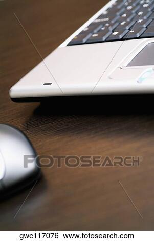 Stock Photograph - Close-up of a laptop with a computer mouse. Fotosearch