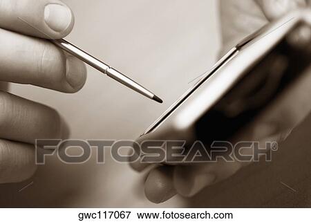 Close-up of a person's hand using a personal data assistant View Large Photo Image Stock Photo - Close-up of a person's hand using a personal data assistant. Fotosearch