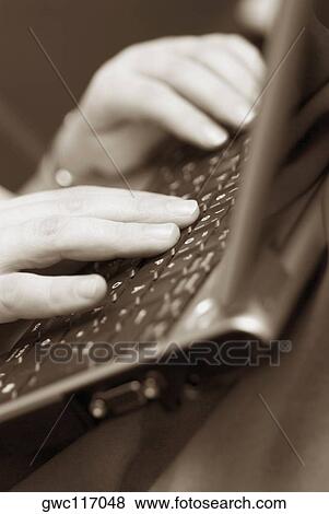 Stock Photo - Close-up of a person's hands using a laptop. Fotosearch
