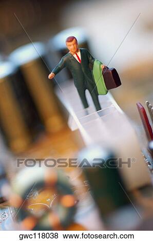 Close-up of the figurine of a businessman with a briefcase on a circuit board View Large Photo Image Stock Photo - Close-up of the figurine of a businessman with a briefcase on a circuit board. Fotosearch