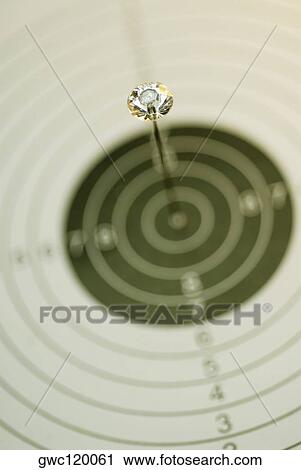 Stock Image - Close-up of a dart on a dartboard. Fotosearch