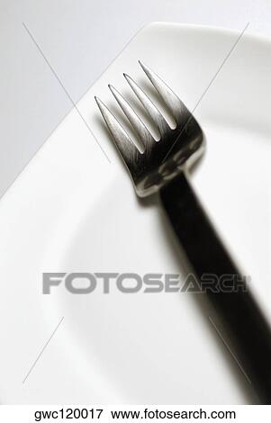Close-up of a fork and a plate View Large Photo Image Stock Photo - Close-up of a fork and a plate. Fotosearch