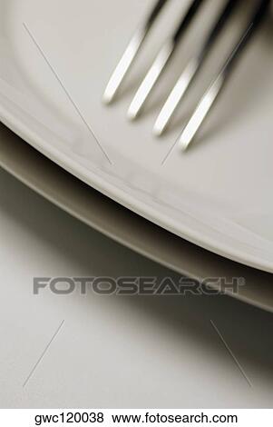 Stock Photo - Close-up of a stack of plates and a fork. Fotosearch