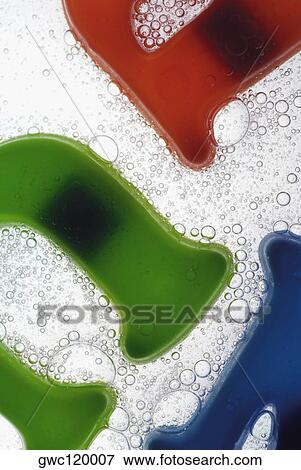 Stock Photo - Close-up of plastic alphabets in a glass of water. Fotosearch