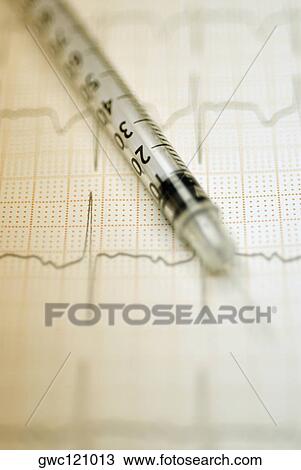 Stock Image - Close-up of an injection on paper. Fotosearch