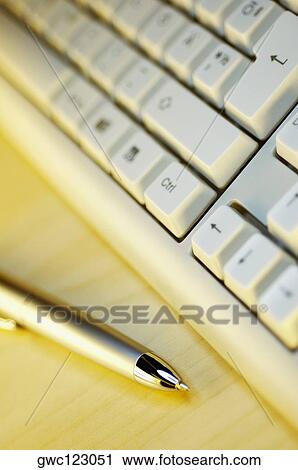 Stock Image - Close-up of a computer keyboard near a pen. Fotosearch
