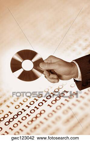 Stock Image - Close-up of a human hand holding a CD. Fotosearch