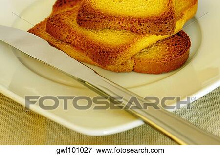 Stock Photo - Close-up of slices of toast in a plate with a butter knife. Fotosearch