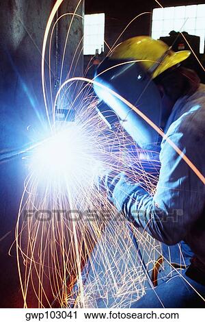 Stock Image - Welder welding a large tank, Chicago, Illinois, USA. Fotosearch