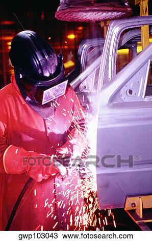 Stock Image - Welder working on car doors in an assembly line, Newark, Delaware, USA. Fotosearch