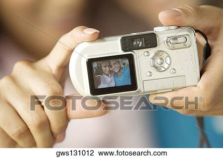 Close-up of a person's hand holding a digital camera View Large Photo Image Stock Image - Close-up of a person's hand holding a digital camera. Fotosearch