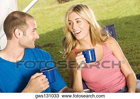 Stock Image - Close-up of a young couple holding coffee cups. Fotosearch
