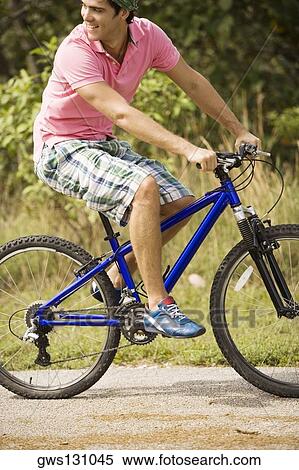 Stock Photography - Close-up of a young man riding a bicycle. Fotosearch
