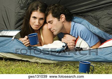 Close-up of a young woman and a mid adult man lying in a tent View Large Photo Image Stock Photo - Close-up of a young woman and a mid adult man lying in a tent. Fotosearch