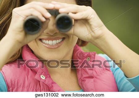 Close-up of a young woman looking through a pair of binoculars View Large Photo Image Stock Image - Close-up of a young woman looking through a pair of binoculars. Fotosearch