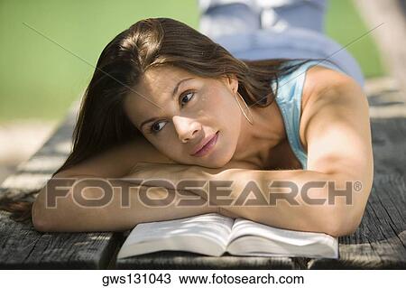 Close-up of a young woman lying on a bench View Large Photo Image Stock Image - Close-up of a young woman lying on a bench. Fotosearch