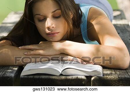 Close-up of a young woman reading a book View Large Photo Image Stock Image - Close-up of a young woman reading a book. Fotosearch
