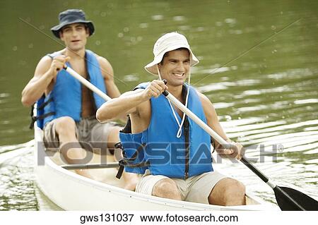 Stock Photo - High angle view of two mid adult men boating in a river. Fotosearch