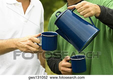 Mid section view of a man pouring tea into a cup View Large Photo Image Stock Image - Mid section view of a man pouring tea into a cup. Fotosearch