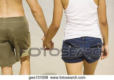 Mid section view of a young man and a teenage girl holding hands View Large Photo Image Stock Photo - Mid section view of a young man and a teenage girl holding hands. Fotosearch