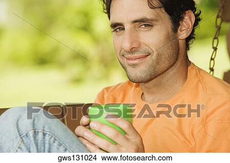 Picture - Portrait of a mid adult man holding a coffee cup. Fotosearch